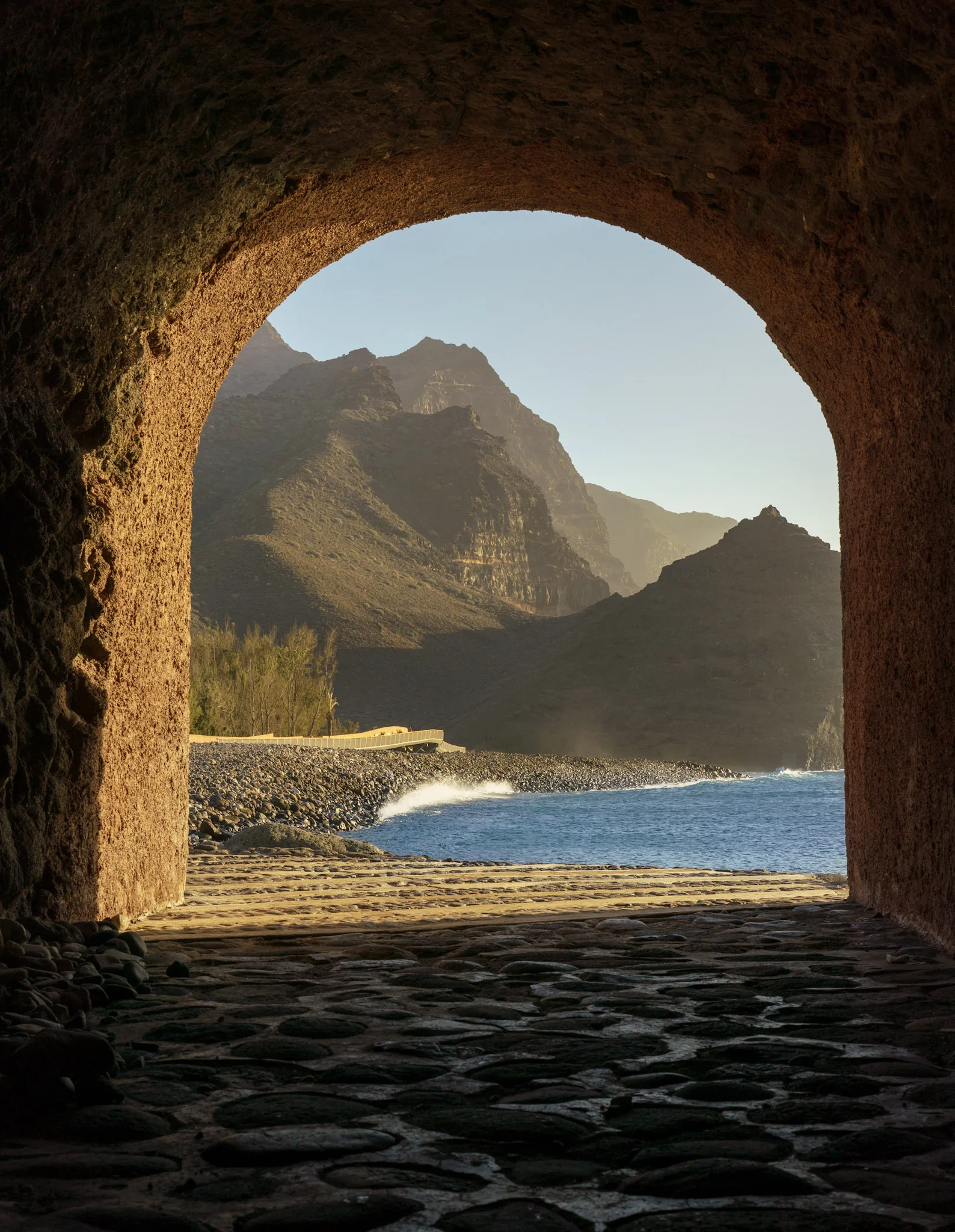 Motorsykkel på svingete fjellvei med grønne åser